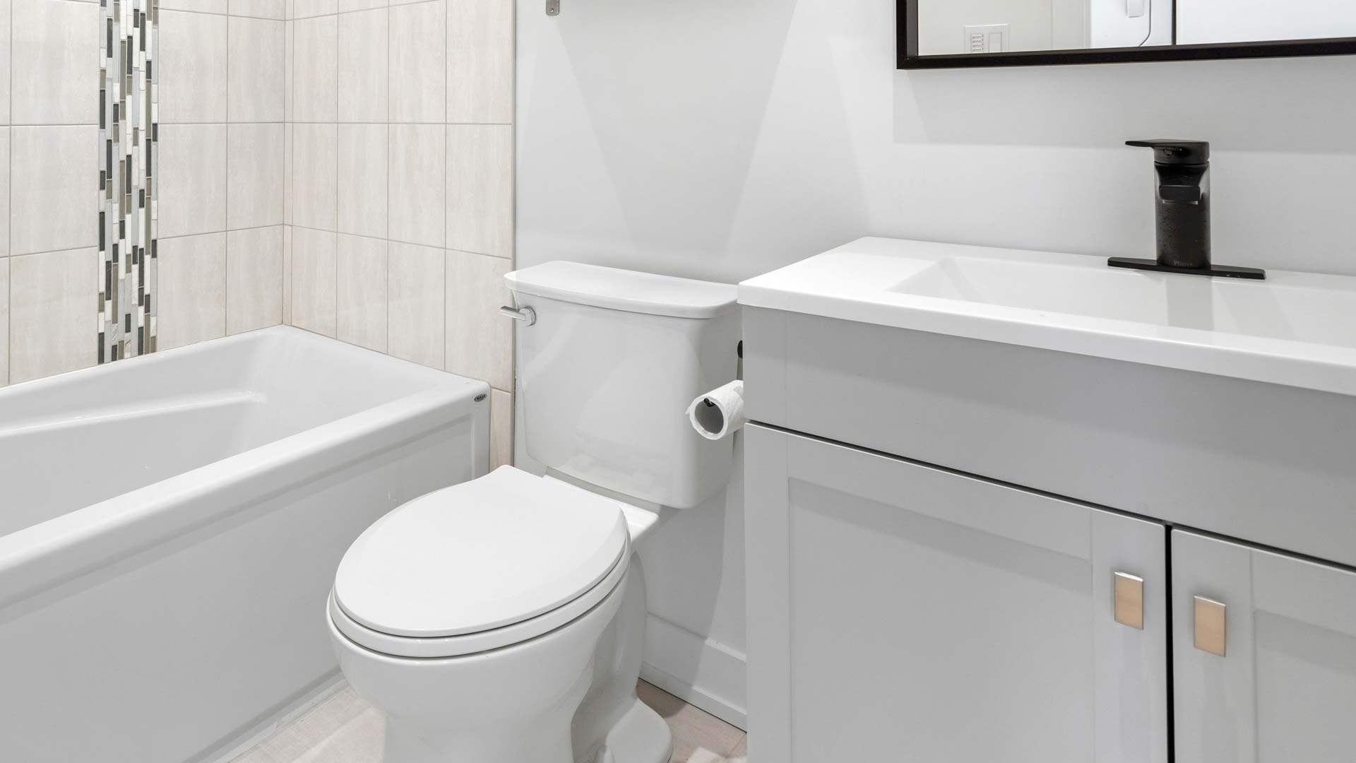 Clean white bathroom, toilet in center of image.