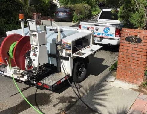 Plumber performing hydro-jetting to clear a clogged drain