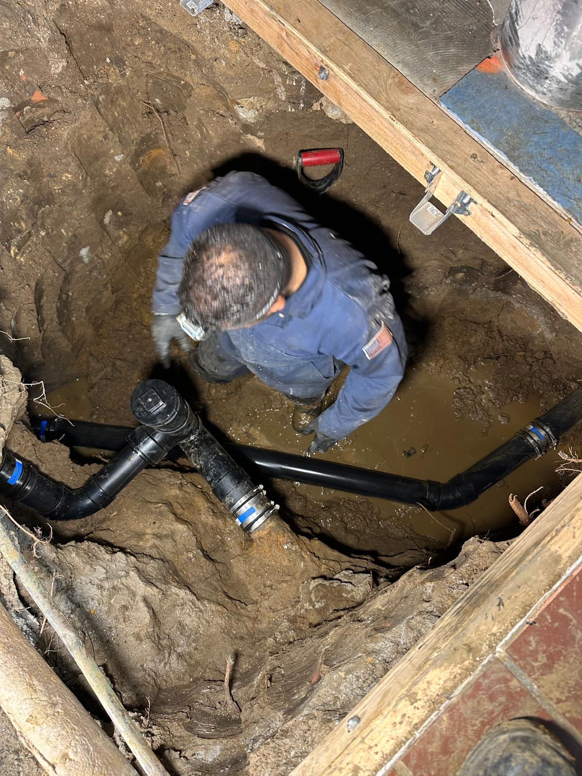 Drain cleaning technician removing debris from clogged pipe