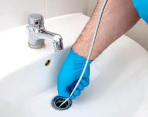 Drain cleaning service removing clog from kitchen sink
