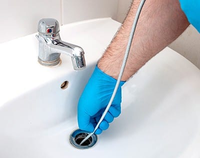 Drain cleaning service removing clog from kitchen sink