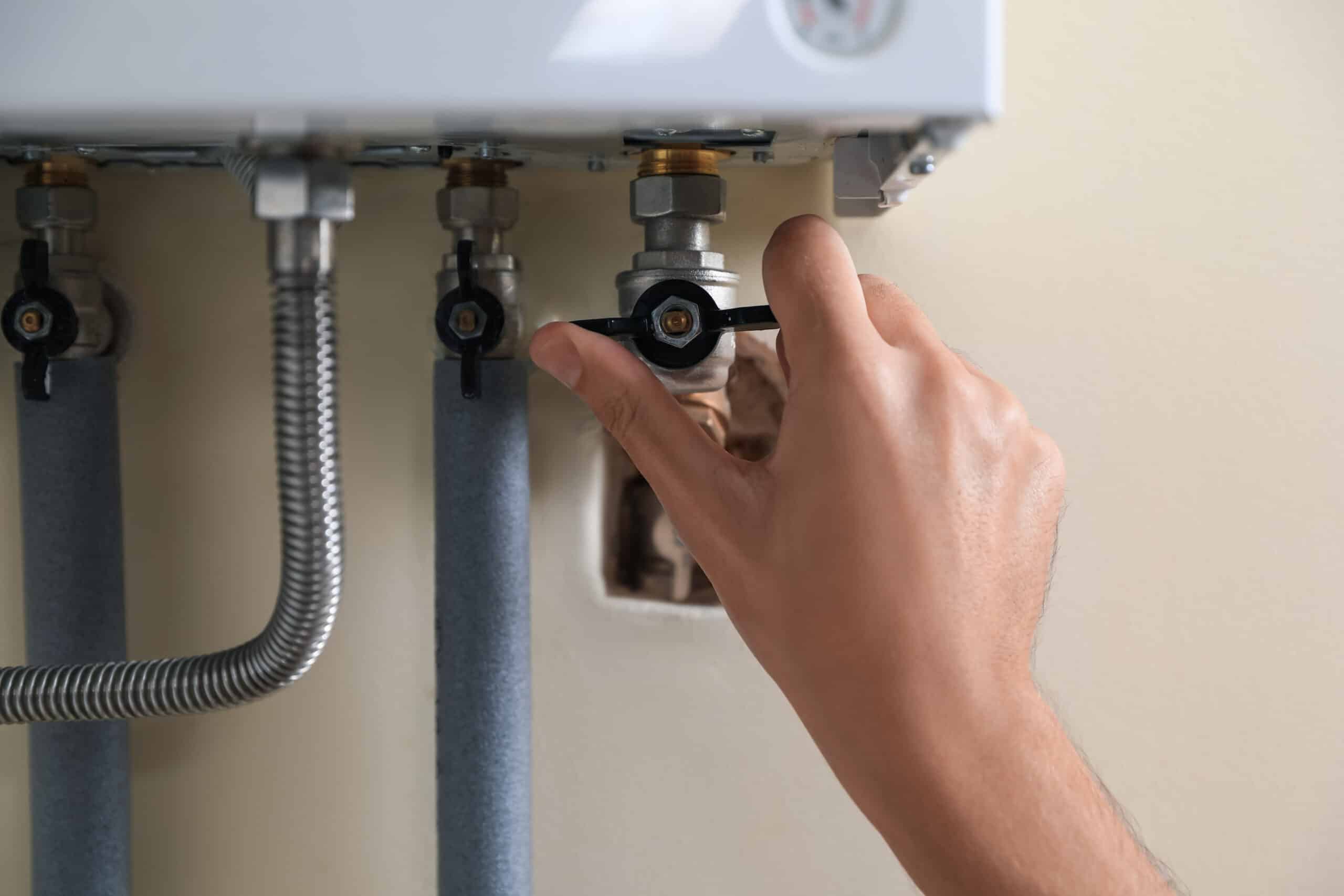 Man's Hand Adjusting Valve on White Wall