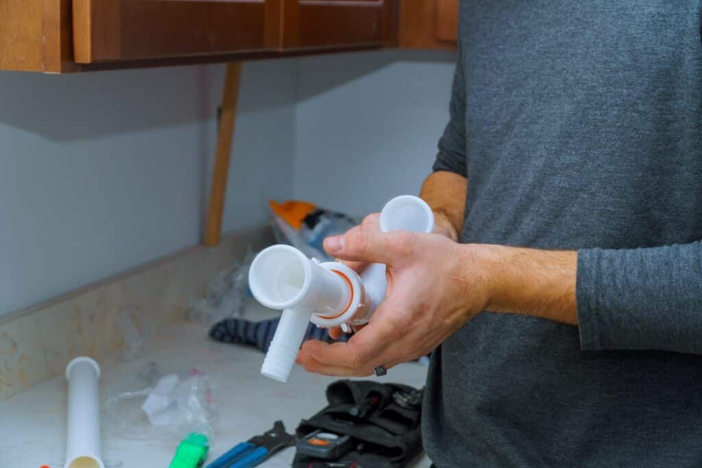 plumber holding pipe fitting component