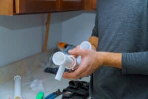 plumber holding pipe fitting component