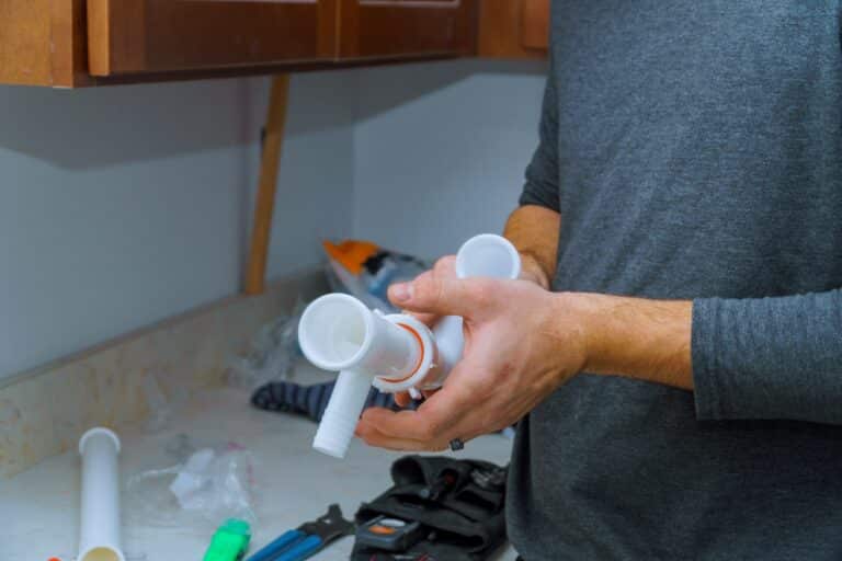 plumber holding pipe fitting component